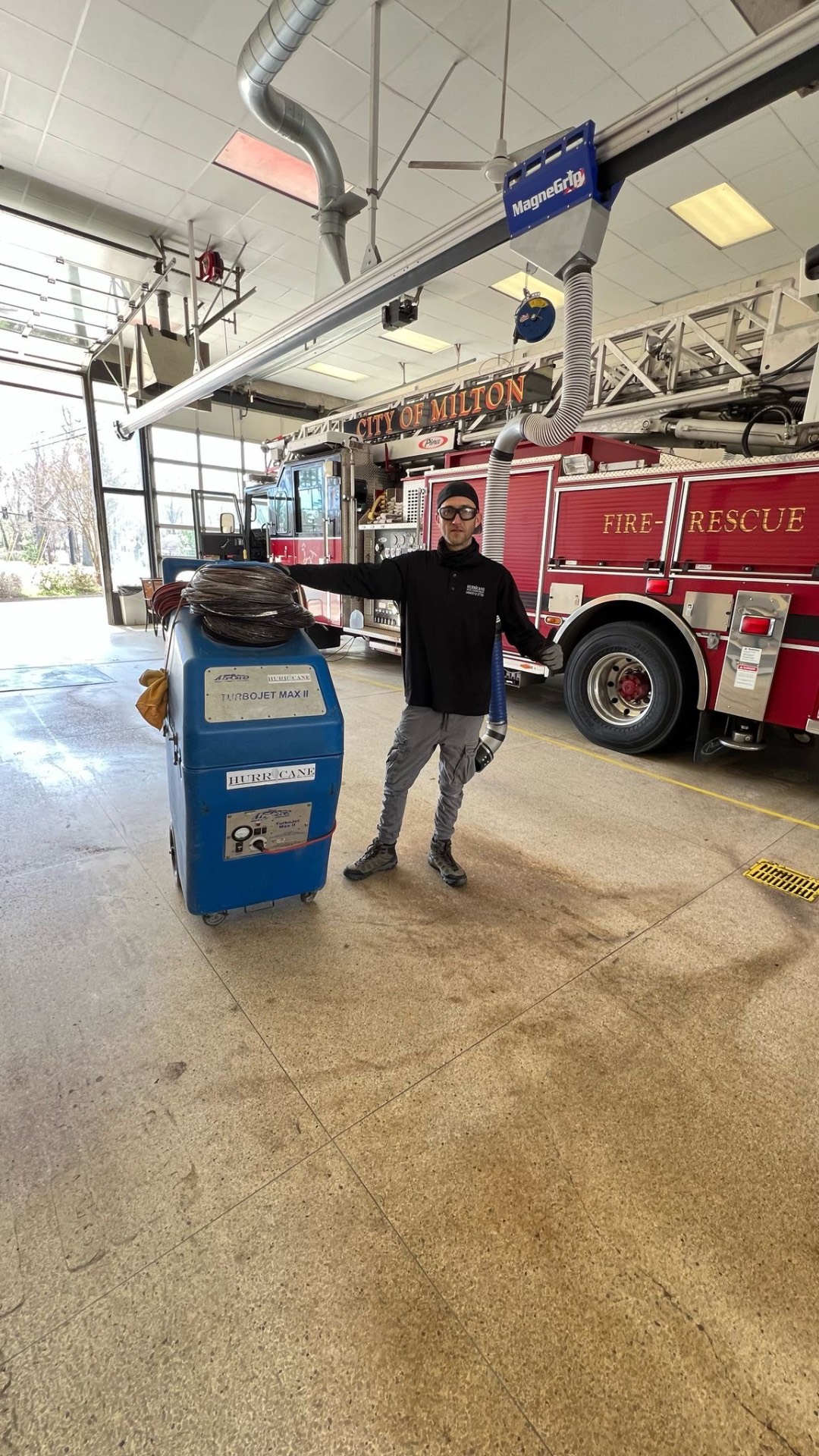 City of Milton Fire-Rescue — Hurricane TurboJet Max II negative-air machine staged in the apparatus bay alongside the ladder truck
