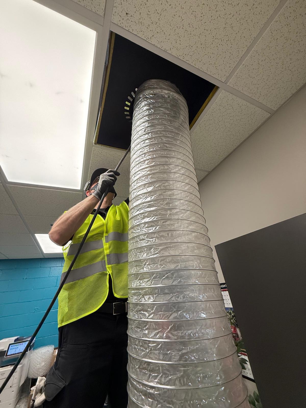 Office cleaning — agitation whip rod driven into supply duct from open ceiling tile